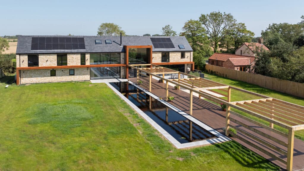 Exterior shot of the rear of the Lincolnshire Grand Designs project featuring SVG20 sliding doors, SF75eco bifold doors, aluminium windows and large fixed frame picture window