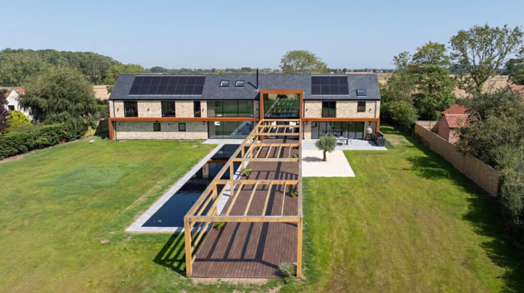 Exterior shot of the rear of the Lincolnshire Grand Designs project featuring SVG20 sliding doors, SF75eco bifold doors, aluminium windows and large fixed frame picture window