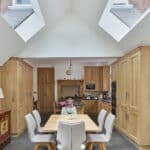 Thumbnail of http://Spacious%20kitchen%20with%20high%20ceiling%20and%20skylights,%20featuring%20wooden%20cabinets,%20a%20dining%20table%20with%20six%20chairs,%20and%20modern%20appliances.