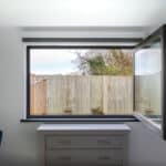 Thumbnail of http://Bedfordshire%20bungalow%20renovation%20featuring%20corner%20sliding%20doors%20opening%20onto%20wooden%20fenced%20garden%20with%20potted%20plants%20and%20modern%20interior.