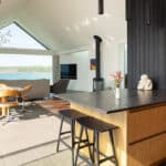 Thumbnail of http://Modern%20open-plan%20living%20space%20with%20a%20kitchen%20island,%20dining%20area,%20seating,%20large%20windows,%20and%20a%20scenic%20coastal%20view%20in%20the%20background.