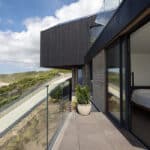 Thumbnail of http://Myrio%20Cornish%20home%20with%20floor-to-ceiling%20sliding%20doors%20opening%20onto%20a%20coastal%20terrace%20overlooking%20Sennen%20Cove%20beach%20and%20turquoise%20sea.