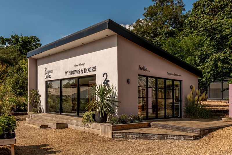The Burgess Group showroom in Woodbridge displaying bifold doors and sliding windows with black frames and glazing systems.