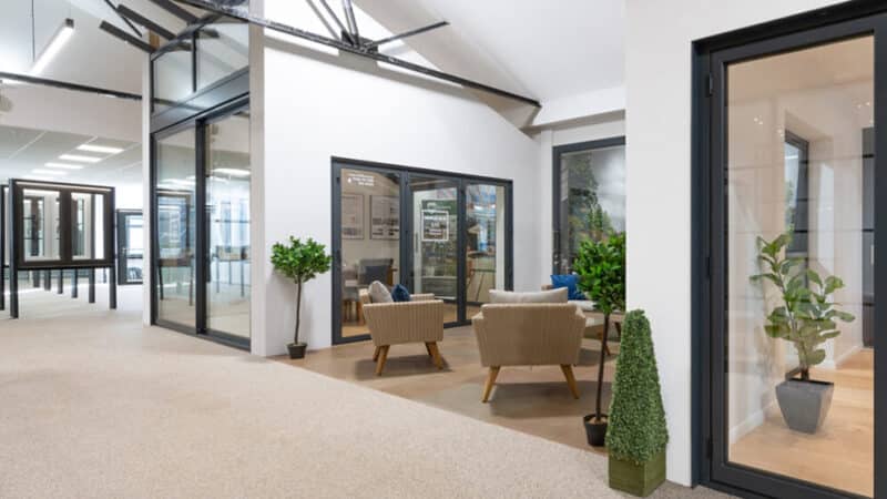 Sunflex UK distributor showroom displaying bifold doors and sliding doors in a modern commercial space with seating areas.