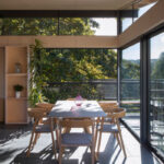 Thumbnail of http://Modern%20dining%20area%20with%20bifold%20doors%20opening%20onto%20a%20terrace%20overlooking%20woodland%20landscape,%20wooden%20furniture%20and%20natural%20light.