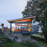 Thumbnail of http://Modern%20glass%20pavilion%20with%20bifold%20doors%20extending%20from%20stone%20cottage,%20illuminated%20interior,%20countryside%20setting.