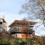 Thumbnail of http://Modern%20glass%20pavilion%20extension%20with%20wooden%20cladding%20and%20bifold%20doors%20attached%20to%20historic%20Scottish%20stone%20building.